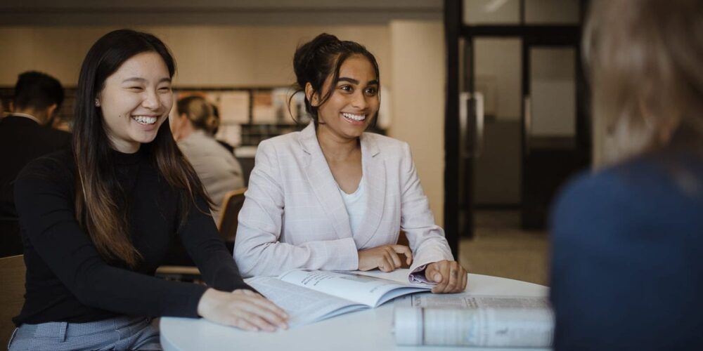 Two students sitting at a table receiving advice