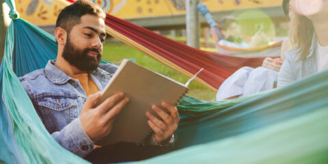 Curtin student outside on a hammock and reading