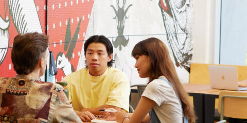 Group of curtin students chatting at a table in a study space