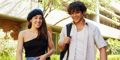 Two curtin students walking outside, talking and smiling