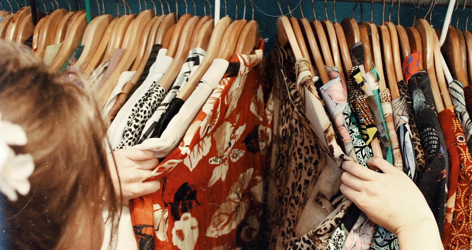 Student looking through clothes on a rack.