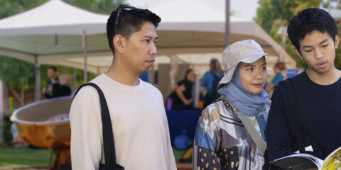 Student with their parents learning from a Curtin staff member about Curtin courses.