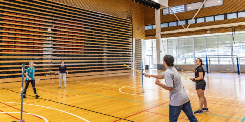 Students playing badminton at Curtin Stadium.