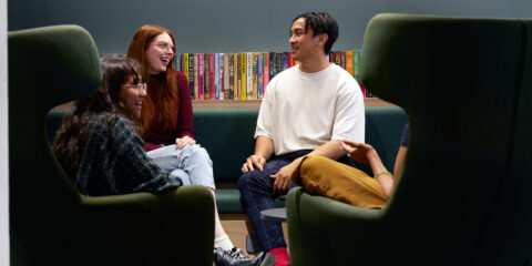 Three students talking in the Library.