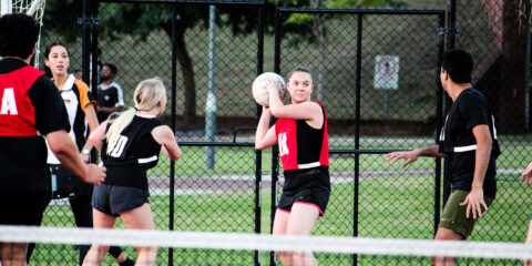 Students playing netball on the Curtin Stadium outdoor courts.