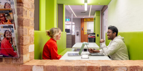 A female and male student sitting at a bench and talking in the Kalgoorlie Library