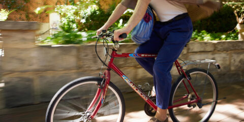 Person cycling on a bike through Curtin Perth campus.