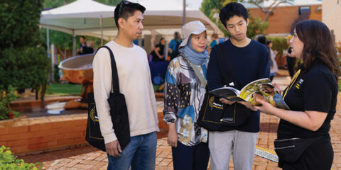 A student and their parents getting advice from Curtin staff at an expo.