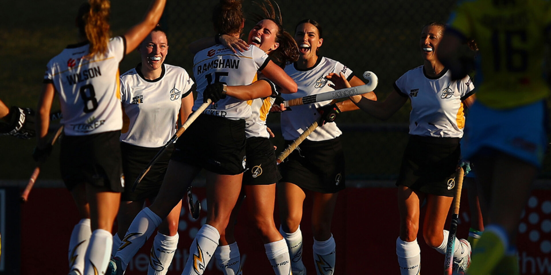 A group of hockey players celebrating at the Hockey Stadium.