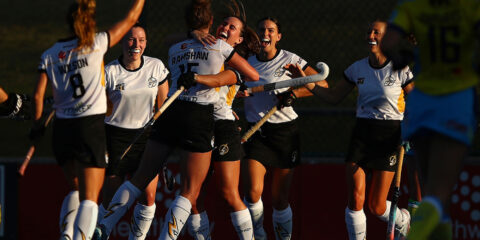 A group of hockey players celebrating at the Hockey Stadium.