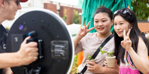 Two female students posing for a photobooth camera.