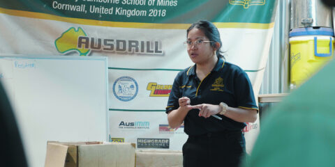 A female mining staff member giving a lecture to a group.