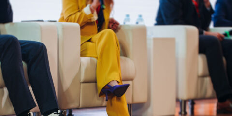 People sitting on chairs on a panel.