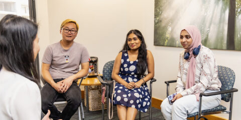 Students seated in a small group counselling session with a facilitator in a campus room.