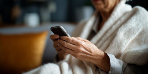Person wearing a robe holding a phone.